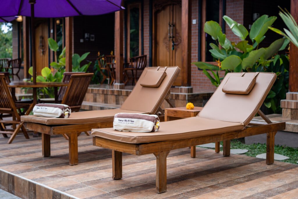 Poolside sun loungers at Yama Villa & Spa Ubud surrounded by tropical greenery